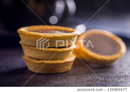 Sweet chocolate tartelettes on black table. Sweet chocolate tartelettes on black table. 130960477
