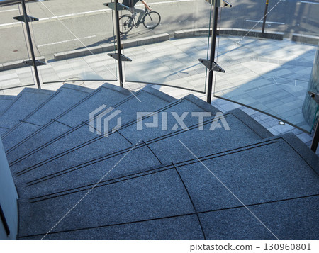 View of a cyclist crossing a city street and stairs View of a cyclist crossing a city street and stairs 130960801