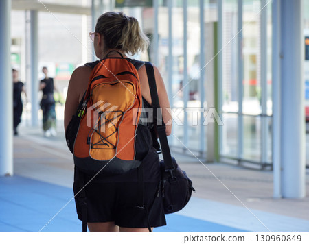 A female foreign tourist crossing the west plaza of Kanazawa Station on a summer morning 130960849