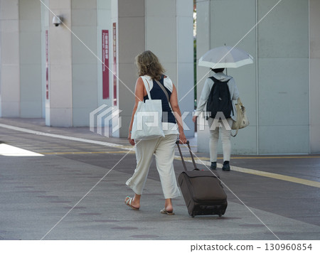 夏日清晨，拖著行李箱的外國遊客穿過金澤站東側的Hospitality Dome廣場 130960854