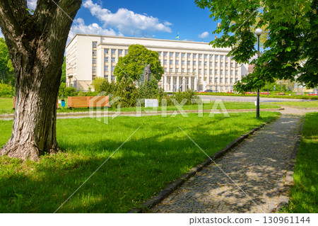 uzhhorod, ukraine - 06 may, 2017: government building of zakarpattia state administration. czechoslovakia architecture and cobblestone street of transcarpathia capital in evening light. narodna square uzhhorod, ukraine - 06 may, 2017: government building of zakarpattia state administration. czechoslovakia architecture and cobblestone street of transcarpathia capital in evening light. narodna square 130961144