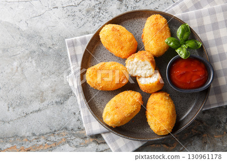Delicious crispy fried breaded chicken croquettes served with tomato sauce close-up in a plate. Horizontal top view 130961178