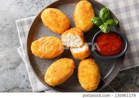 Hot chicken bechamel croquettes with ketchup close-up in a plate. Horizontal top view Hot chicken bechamel croquettes with ketchup close-up in a plate. Horizontal top view 130961179