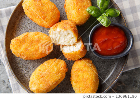 Breaded and fried chicken Croquettes served tomato sauce close-up in a plate. Horizontal top view Breaded and fried chicken Croquettes served tomato sauce close-up in a plate. Horizontal top view 130961180
