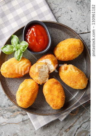 Chicken Croquettes Croquetas de Pollo with ketchup close-up in a plate. Vertical top view 130961182