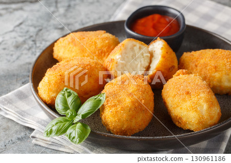 Breaded and fried chicken Croquettes served tomato sauce close-up in a plate. Horizontal Breaded and fried chicken Croquettes served tomato sauce close-up in a plate. Horizontal 130961186
