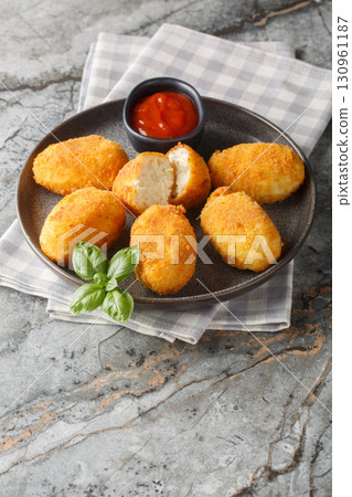 Close-up of Spanish chicken croquettes with ketchup in a plate. Vertical Close-up of Spanish chicken croquettes with ketchup in a plate. Vertical 130961187