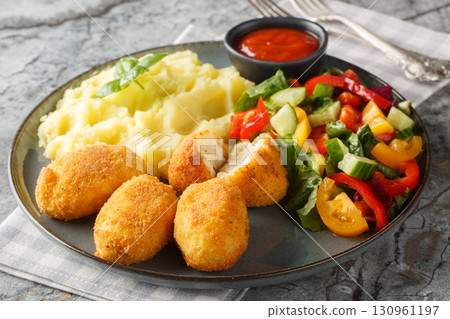 Spanish Croquettes chicken in a creamy bechamel sauce served with mashed potatoes, fresh salad and tomato sauce close-up in a plate. Horizontal Spanish Croquettes chicken in a creamy bechamel sauce served with mashed potatoes, fresh salad and tomato sauce close-up in a plate. Horizontal 130961197