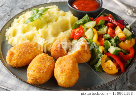 Breaded and fried chicken Croquettes served with mashed potatoes, fresh salad and tomato sauce close-up in a plate. Horizontal Breaded and fried chicken Croquettes served with mashed potatoes, fresh salad and tomato sauce close-up in a plate. Horizontal 130961198