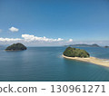 Aerial view of blue sea and sky, white clouds, and an uninhabited island floating in the Seto Inland Sea 130961271