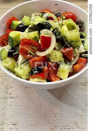 A vibrant Mediterranean salad featuring tomatoes, cucumbers, olives, and feta cheese, perfect for any meal. Close-up. A vibrant Mediterranean salad featuring tomatoes, cucumbers, olives, and feta cheese, perfect for any meal. Close-up. 130962268