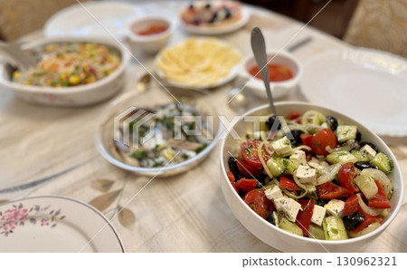 A beautifully arranged and presented table showcasing a delightful variety of fresh, colorful salads and garnishes A beautifully arranged and presented table showcasing a delightful variety of fresh, colorful salads and garnishes 130962321