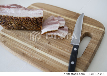Ukrainian traditional cuisine. Very tasty pieces of salo. Raw ukrainian bacon or salo on wooden board. Sliced salted pork lard (salo). Food concept. 130962348