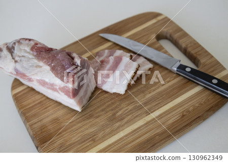 Ukrainian traditional cuisine. Very tasty pieces of salo. Raw ukrainian bacon or salo on wooden board. Sliced salted pork lard (salo). Food concept. Ukrainian traditional cuisine. Very tasty pieces of salo. Raw ukrainian bacon or salo on wooden board. Sliced salted pork lard (salo). Food concept. 130962349