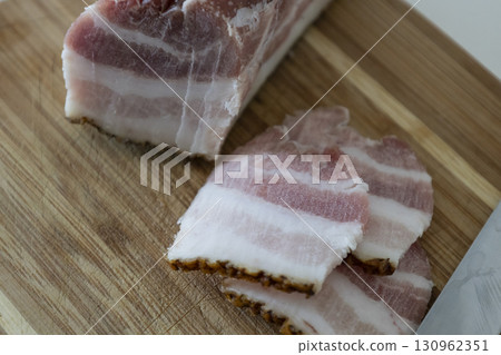 Ukrainian traditional cuisine. Very tasty pieces of salo. Raw ukrainian bacon or salo on wooden board. Sliced salted pork lard (salo). Food concept. Ukrainian traditional cuisine. Very tasty pieces of salo. Raw ukrainian bacon or salo on wooden board. Sliced salted pork lard (salo). Food concept. 130962351