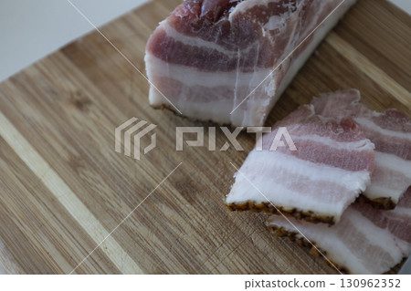 Ukrainian traditional cuisine. Very tasty pieces of salo. Raw ukrainian bacon or salo on wooden board. Sliced salted pork lard (salo). Food concept. Ukrainian traditional cuisine. Very tasty pieces of salo. Raw ukrainian bacon or salo on wooden board. Sliced salted pork lard (salo). Food concept. 130962352