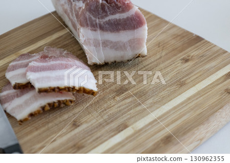 Ukrainian traditional cuisine. Very tasty pieces of salo. Raw ukrainian bacon or salo on wooden board. Sliced salted pork lard (salo). Food concept. Ukrainian traditional cuisine. Very tasty pieces of salo. Raw ukrainian bacon or salo on wooden board. Sliced salted pork lard (salo). Food concept. 130962355