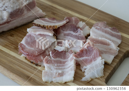 Ukrainian traditional cuisine. Very tasty pieces of salo. Raw ukrainian bacon or salo on wooden board. Sliced salted pork lard (salo). Food concept. Ukrainian traditional cuisine. Very tasty pieces of salo. Raw ukrainian bacon or salo on wooden board. Sliced salted pork lard (salo). Food concept. 130962356