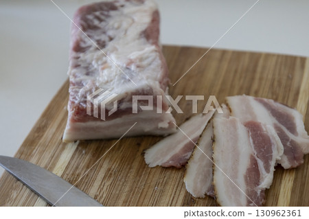 Ukrainian traditional cuisine. Very tasty pieces of salo. Raw ukrainian bacon or salo on wooden board. Sliced salted pork lard (salo). Food concept. 130962361