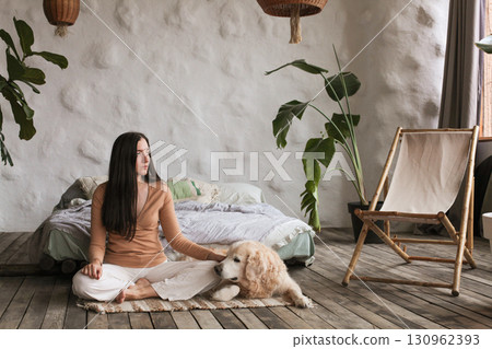 Practicing mindfulness with a golden retriever in a cozy hotel room 130962393