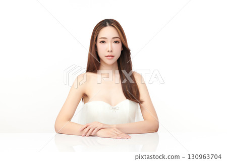 A beautiful young Asian woman with clean, fresh skin against a white background. Skincare, facial treatment, cosmetology, beauty, and spa. An elegant portrait of an Asian woman. 130963704
