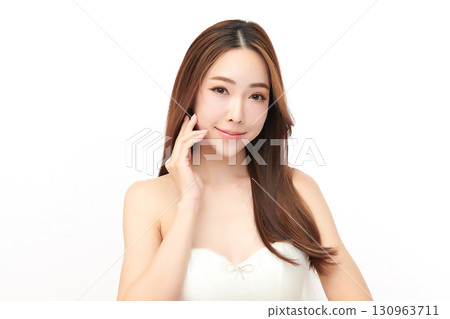 A beautiful young Asian woman with clean, fresh skin against a white background. Skincare, facial treatment, cosmetology, beauty, and spa. An elegant portrait of an Asian woman. 130963711