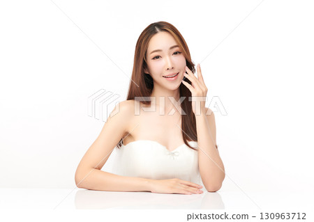 A beautiful young Asian woman with clean, fresh skin against a white background. Skincare, facial treatment, cosmetology, beauty, and spa. An elegant portrait of an Asian woman. 130963712