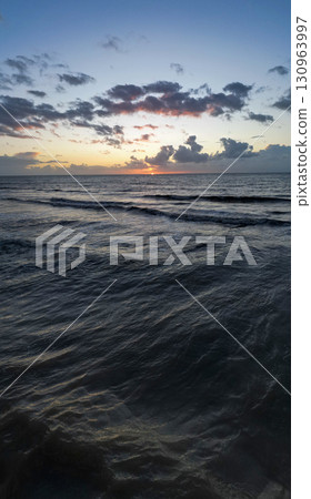 Enjoy a serene, picturesque ocean sunset with gentle waves and a peaceful atmosphere Enjoy a serene, picturesque ocean sunset with gentle waves and a peaceful atmosphere 130963997