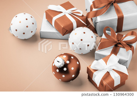 Gift boxes, present with brown bow ribbon and christmas ball decor, christmas holiday light brown background Gift boxes, present with brown bow ribbon and christmas ball decor, christmas holiday light brown background 130964300