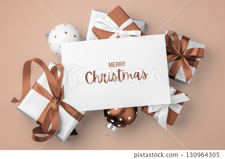 Merry christmas holiday card on gift boxes broown bow ribbon and xmas ball on light brown background 130964305