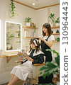 Woman getting colored at a beauty salon 130964443