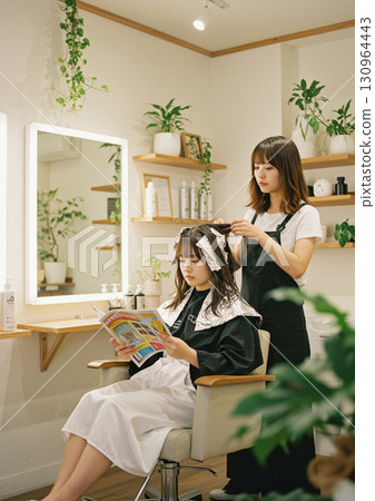 Woman getting colored at a beauty salon 130964443