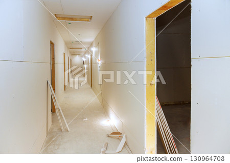 Construction workers renovating hallway in new building space during work day hours 130964708