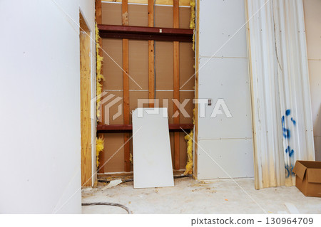 Construction site showing unfinished interior with exposed walls materials during renovation process Construction site showing unfinished interior with exposed walls materials during renovation process 130964709