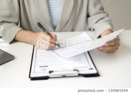 Business woman employer holding resume hiring recruit looking cv resume to hire candidates, analyzing information before job interview. Recruitment concepts Business woman employer holding resume hiring recruit looking cv resume to hire candidates, analyzing information before job interview. Recruitment concepts 130965044