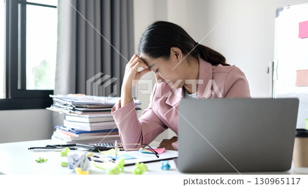Working Asian women feel stressed, tired from work, migraine headaches from hard work while working at the office Working Asian women feel stressed, tired from work, migraine headaches from hard work while working at the office 130965117
