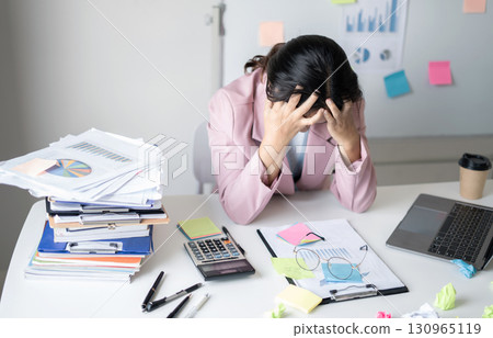 Working Asian women feel stressed, tired from work, migraine headaches from hard work while working at the office 130965119