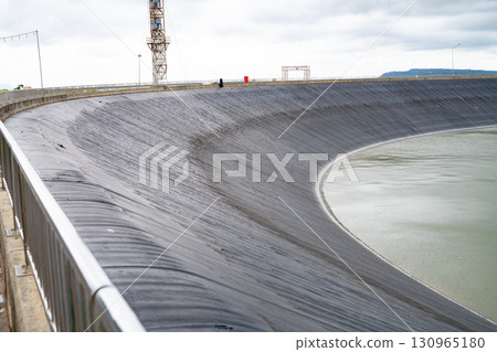 HDPE plastic lined water reservoirs and landscape of wind farm for power generating stations. High density polyethylene engineering material. Wind power. Sustainable, renewable energy. Windmill farm. 130965180
