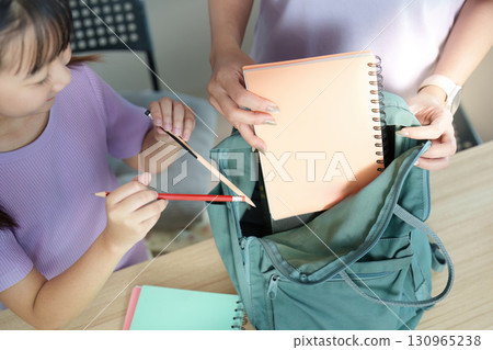Back to School. Child organizing school supplies in backpack. 130965238
