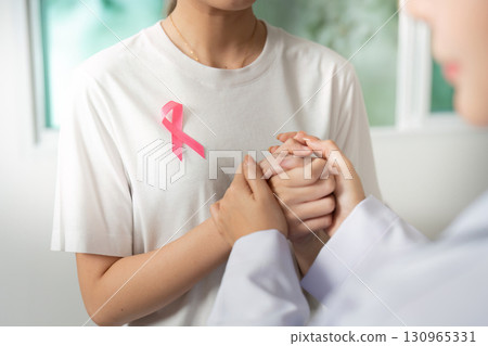 Breast Cancer Support. Two women holding hands, showing solidarity and compassion. 130965331