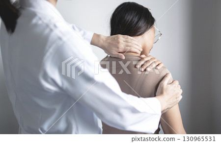 Female physiotherapists provide physical assistance to woman patients with shoulder injuries massaging their shoulders for muscle recovery in the rehabilitation center. Physiotherapy concepts 130965531