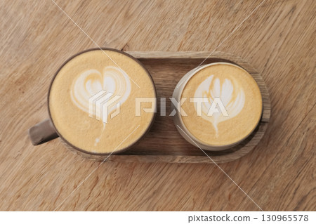 Two cups of hot coffee latte art on wooden table 130965578
