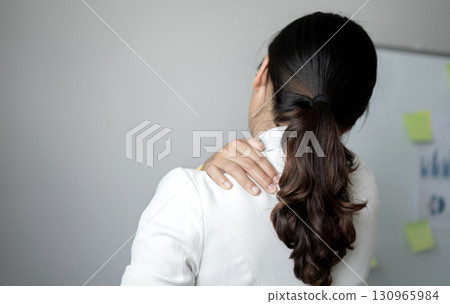 Woman having shoulder pain pain during work long time. stretching to relax and relax while working hard at the office 130965984
