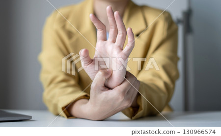 Woman hand with wrist pain numbness and pain in the palm of the hand has pain and tingling in the nerve endings This is a side effect of sitting and working for a long time on a laptop at the office 130966574