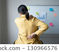 Woman having back and shoulder pain pain during work long time. stretching to relax and relax while working hard at the office 130966576