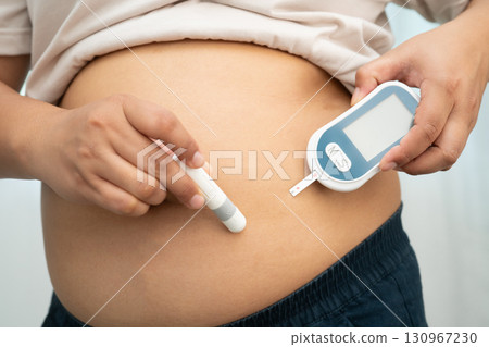 Asian woman injecting herself diabetes injecting insulin in stomach at home. Asian woman injecting herself diabetes injecting insulin in stomach at home. 130967230