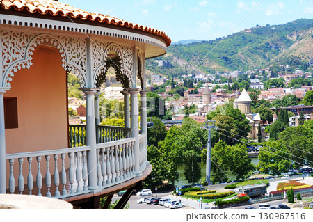 Beautiful balcony view overlooking Tbilisi with lush greenery and historical buildings in the background on a sunny day 130967516