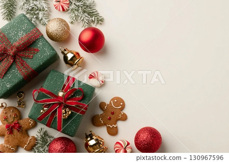 Delightful holiday tableau from top view emerald gift boxes, red, green, and golden baubles, gingerbread man ornament, jingle bells, candies, frosty fir twig, light background with space for greeting Delightful holiday tableau from top view emerald gift boxes, red, green, and golden baubles, gingerbread man ornament, jingle bells, candies, frosty fir twig, light background with space for greeting 130967596