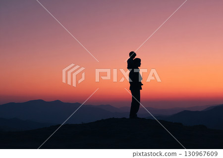Boy sitting on father's shoulders. Father and son standing together on a hill during sunset. 130967609