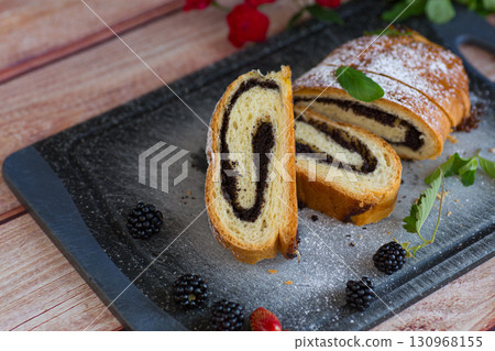 Homemade poppy seed roll with powdered sugar on a tray 130968155